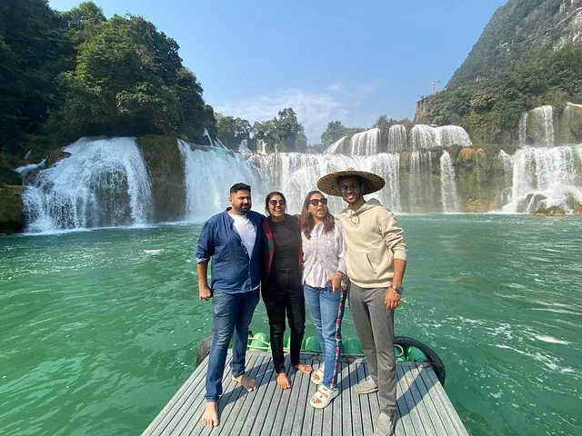 Group of four tourists posing on a raft at Ban Gioc Waterfall.